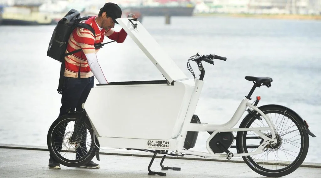 Mann schaut ins Lasten e-Bike von Urban Arrow
