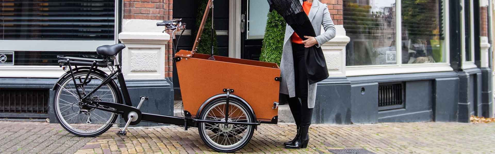Frau packt das Babboe Pro Trike-E