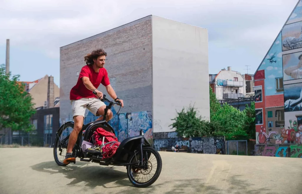 Ein Mann fährt mit dem Lastenrad von Triobike durch die Stadt