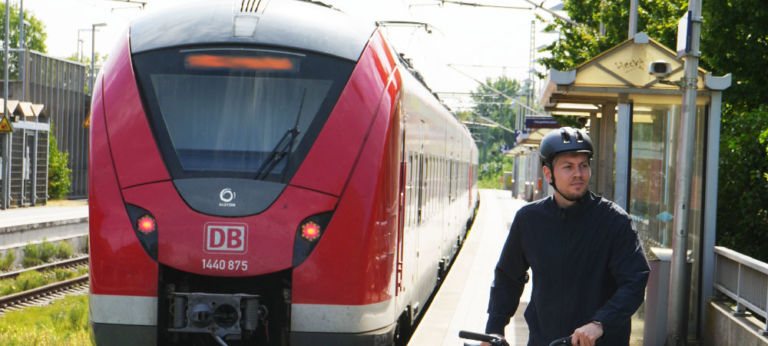 Ein Mann schiebt sein Bike auf dem Bahnhof