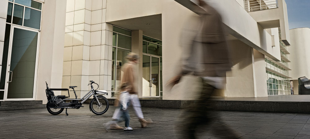 Eine Frau läuft mit Kind am Specialized Turbo Porto vorbei ins Museum